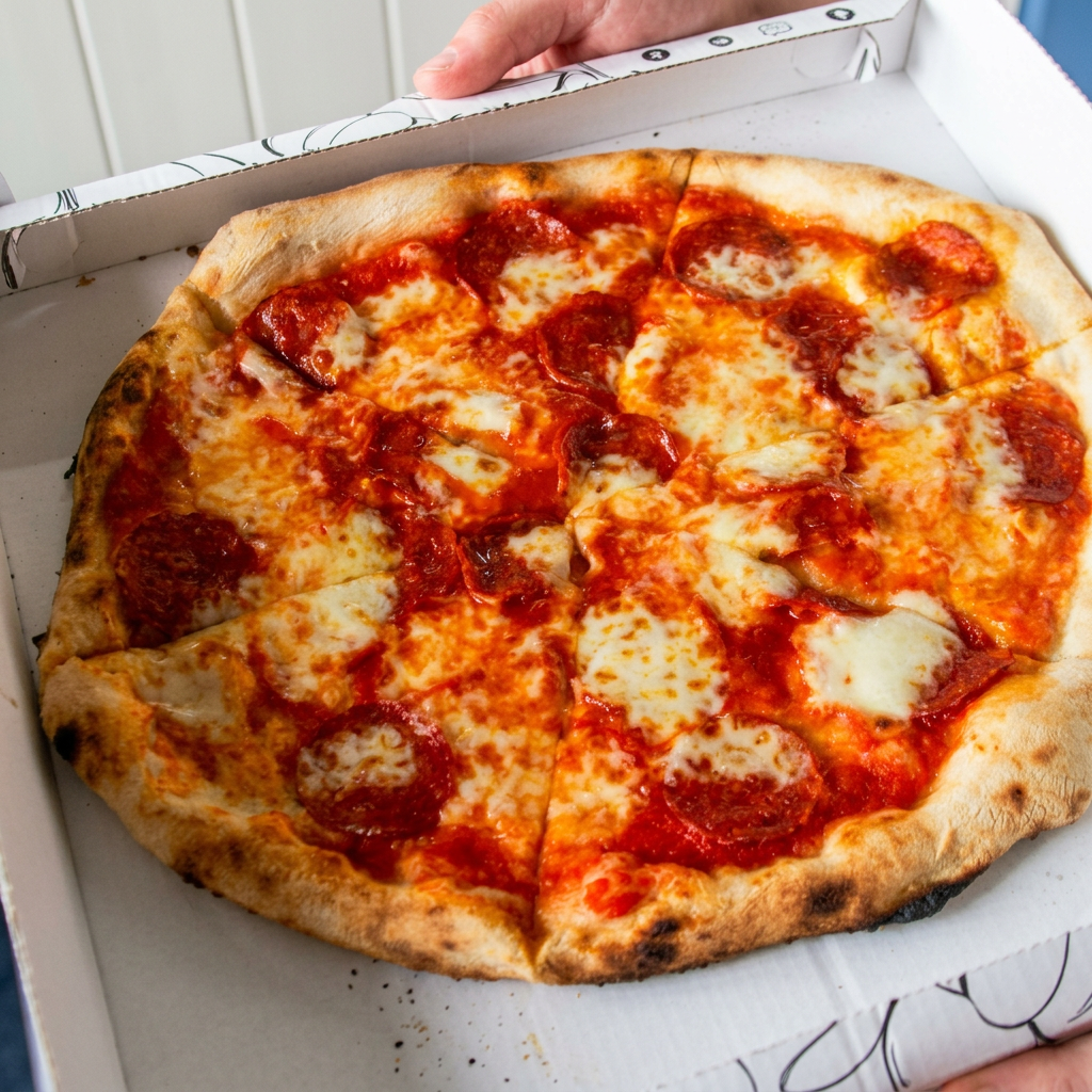 Pepperoni pizza served in a takeaway box